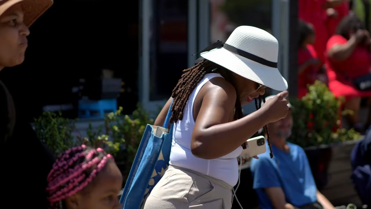 A person wearing a hat and sunglasses
Description automatically generated
