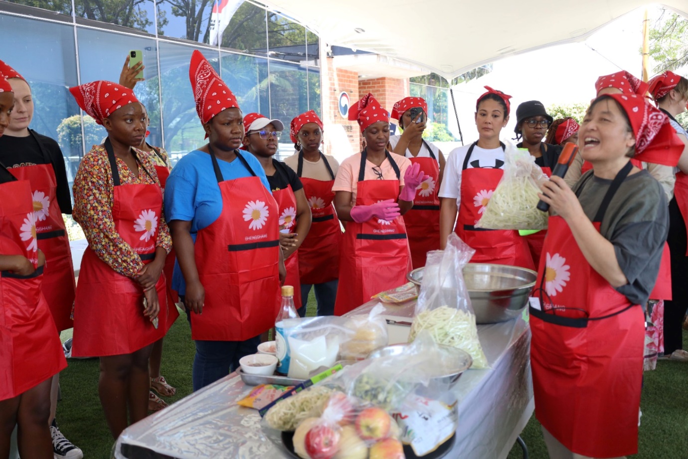 A group of women wearing red aprons

Description automatically generated