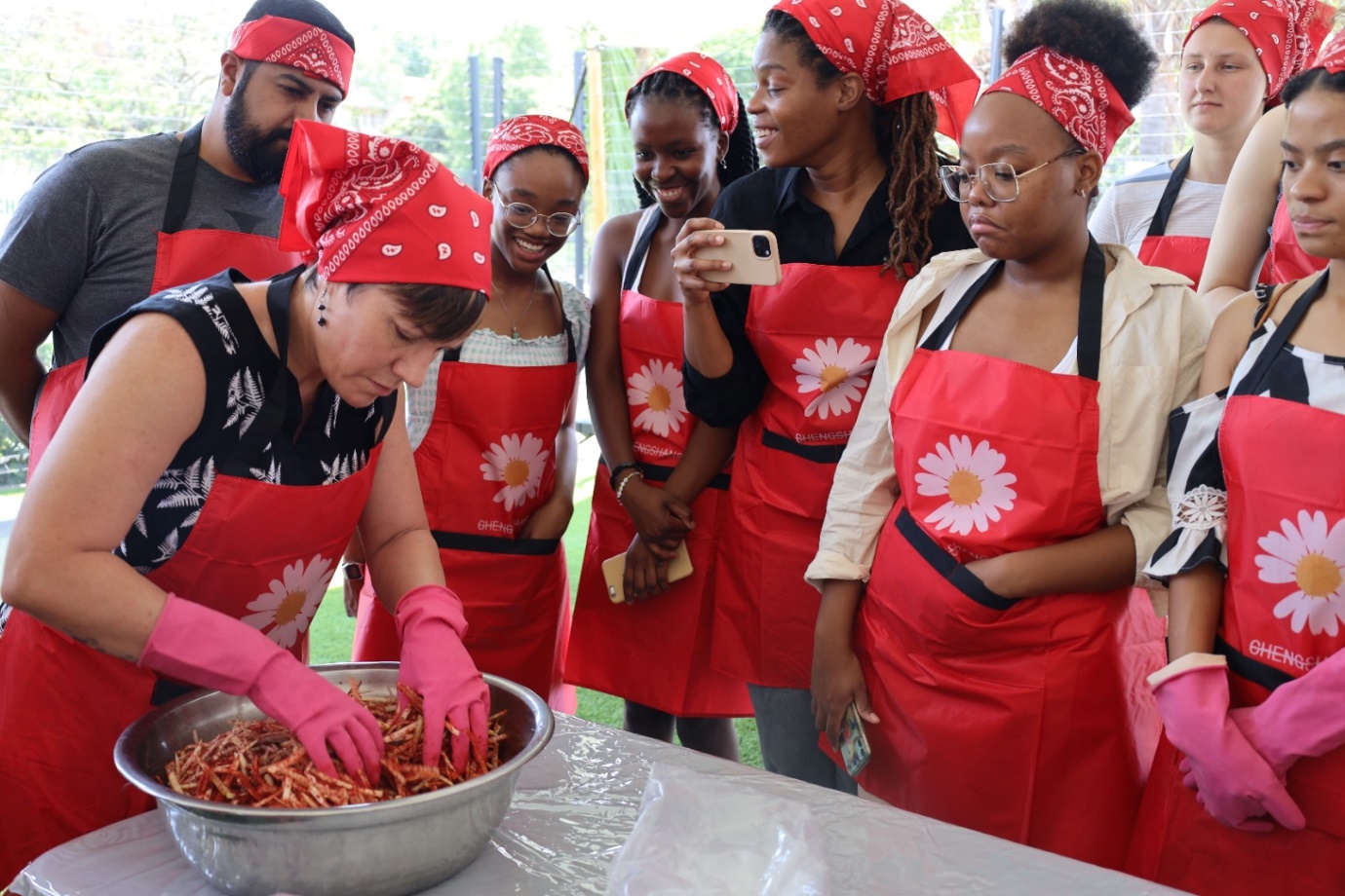 A group of people wearing red aprons

Description automatically generated