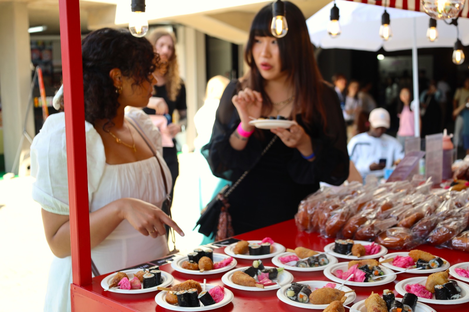 A person standing next to a table of food

Description automatically generated