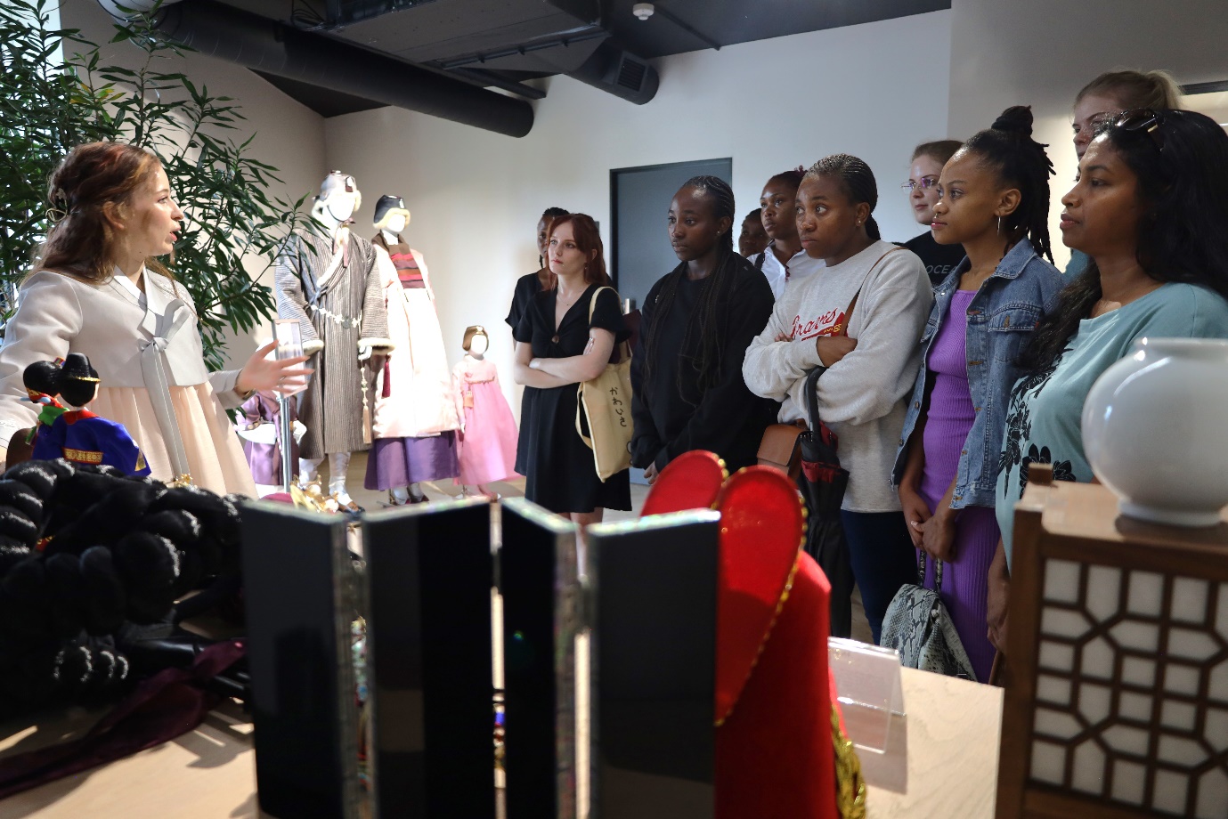 A group of people standing in a room

Description automatically generated