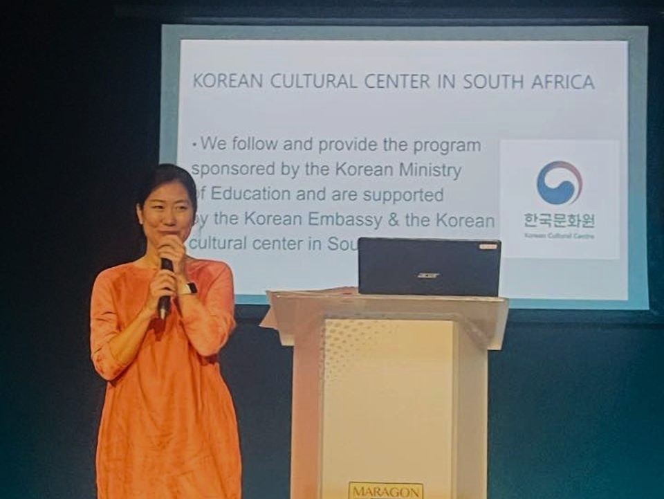 A person standing at a podium with a microphone

Description automatically generated