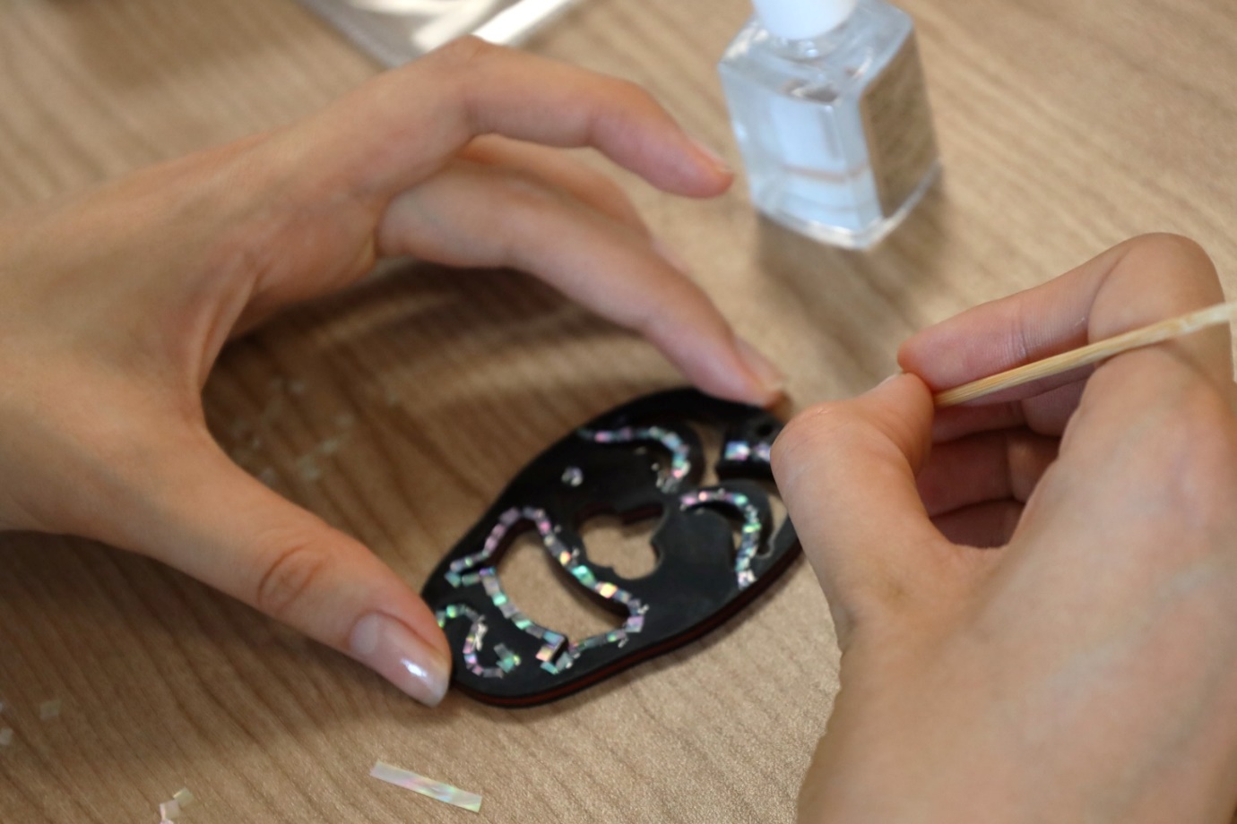 A close-up of hands painting a black object

Description automatically generated