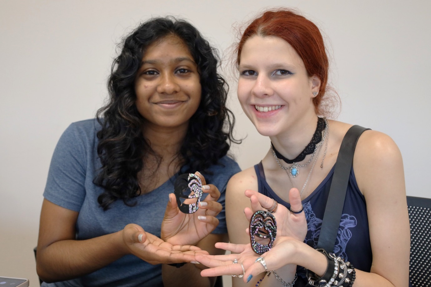 A couple of young women holding up their hands

Description automatically generated