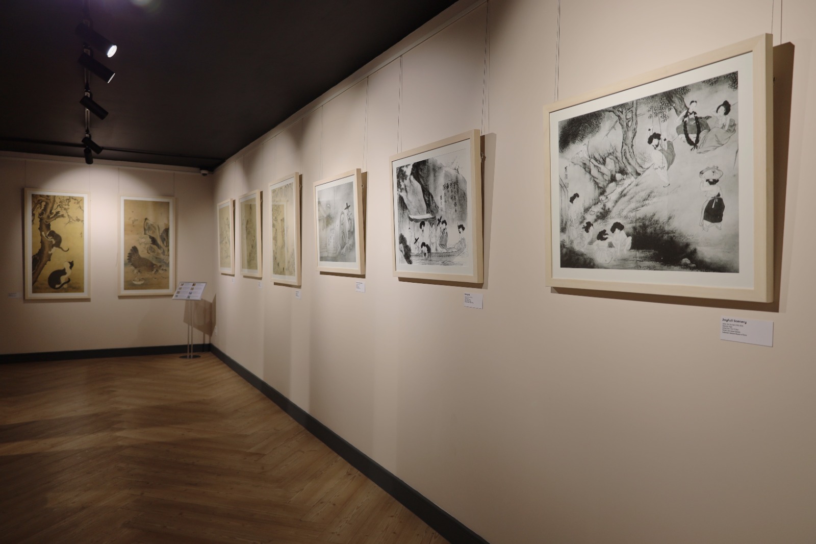 A long hallway with art on the wall

Description automatically generated