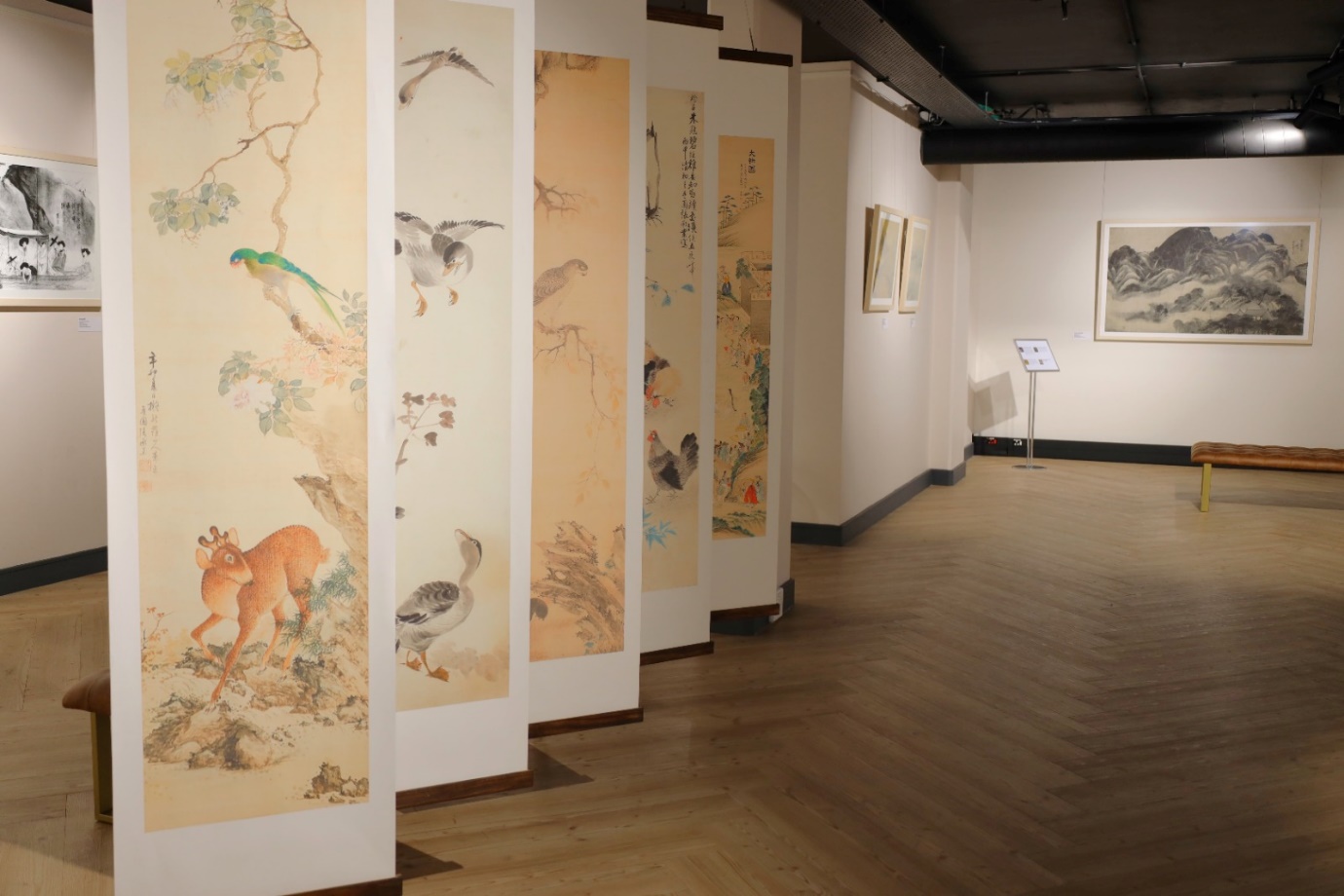 Long shot of a room with paintings

Description automatically generated