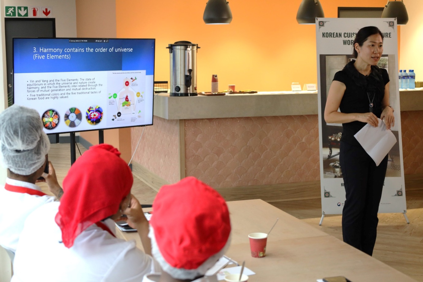 A person giving a presentation to a group of people

Description automatically generated