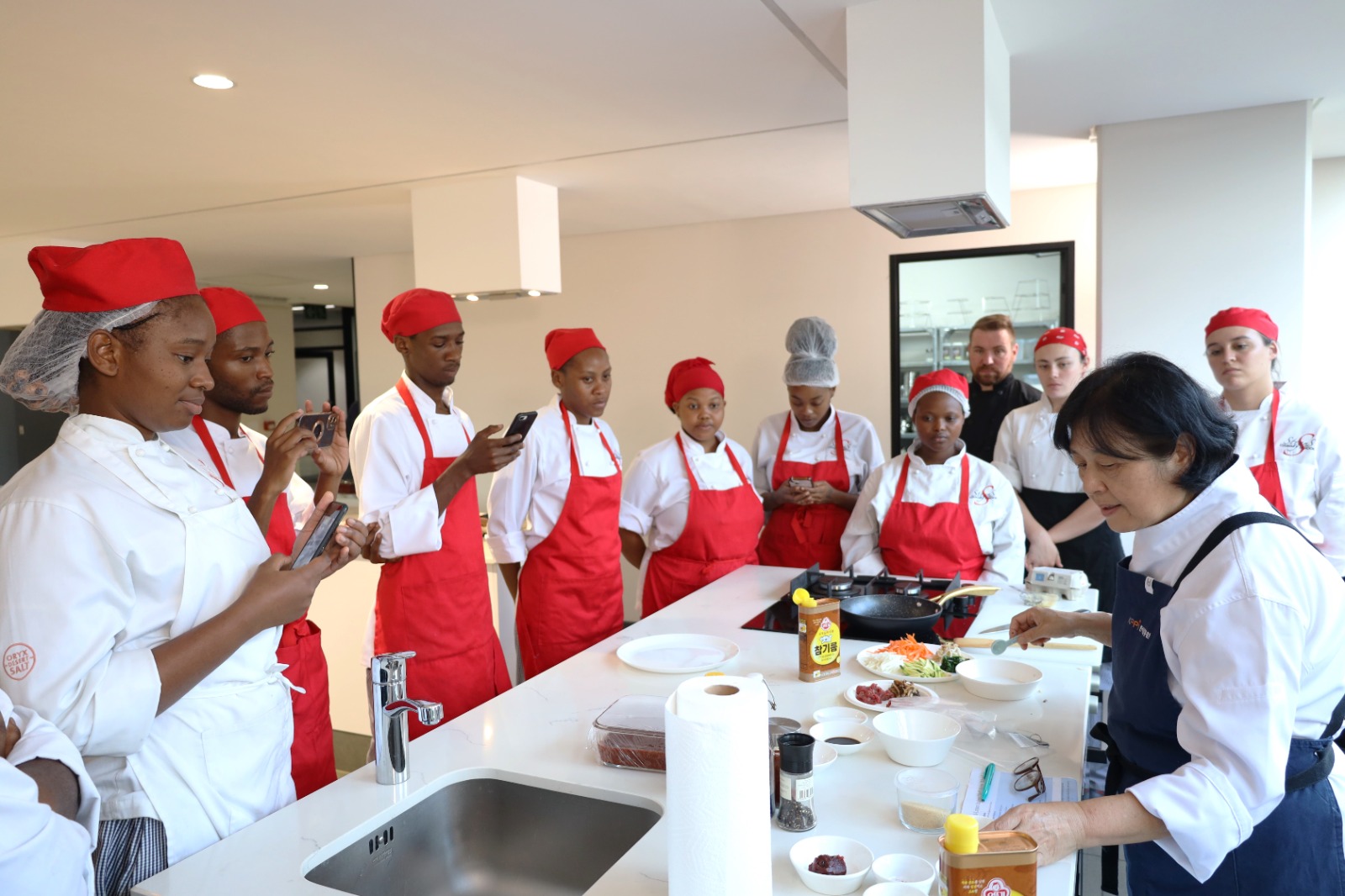 A group of people in a kitchen

Description automatically generated