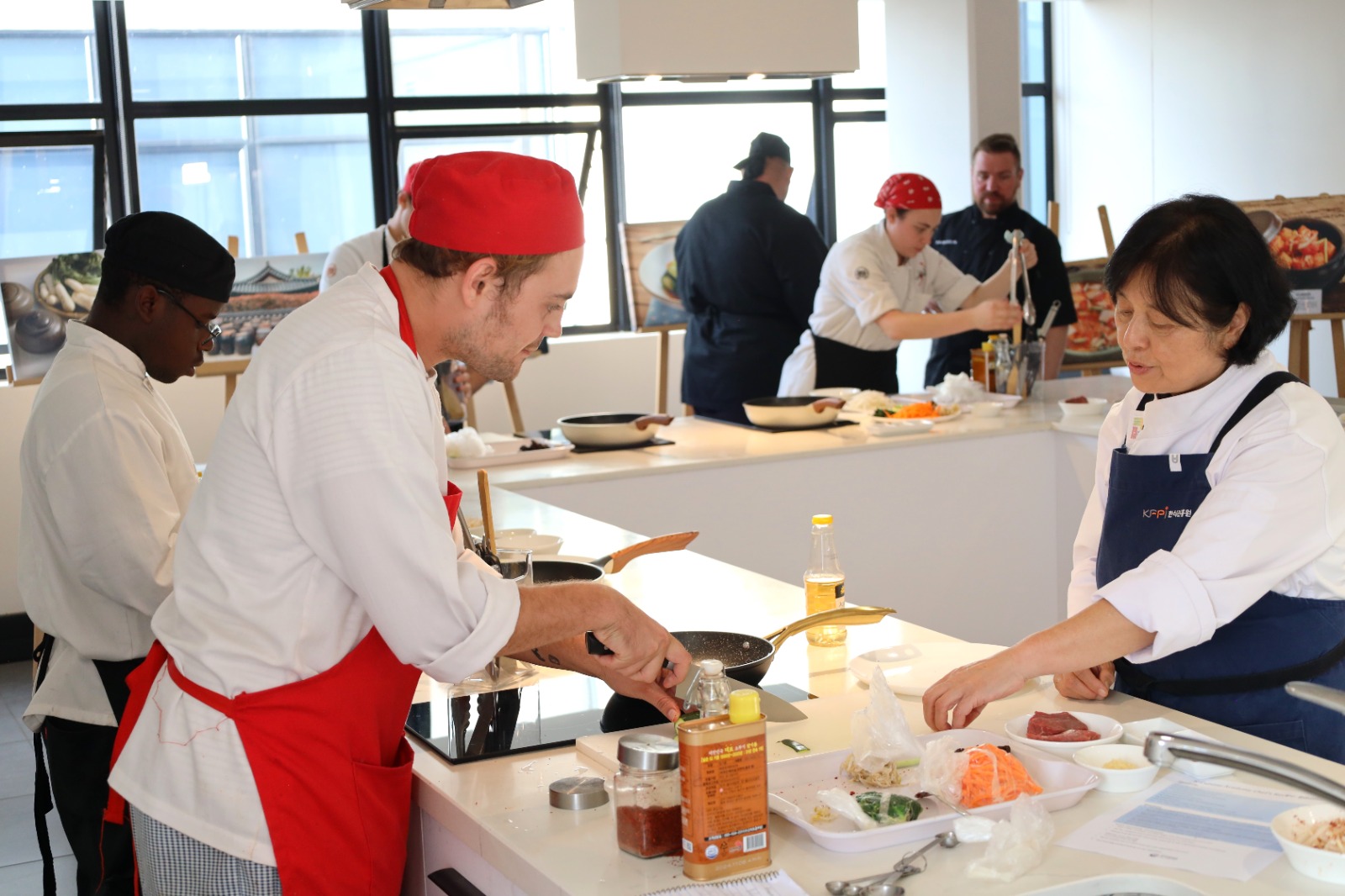A group of people cooking in a kitchen

Description automatically generated