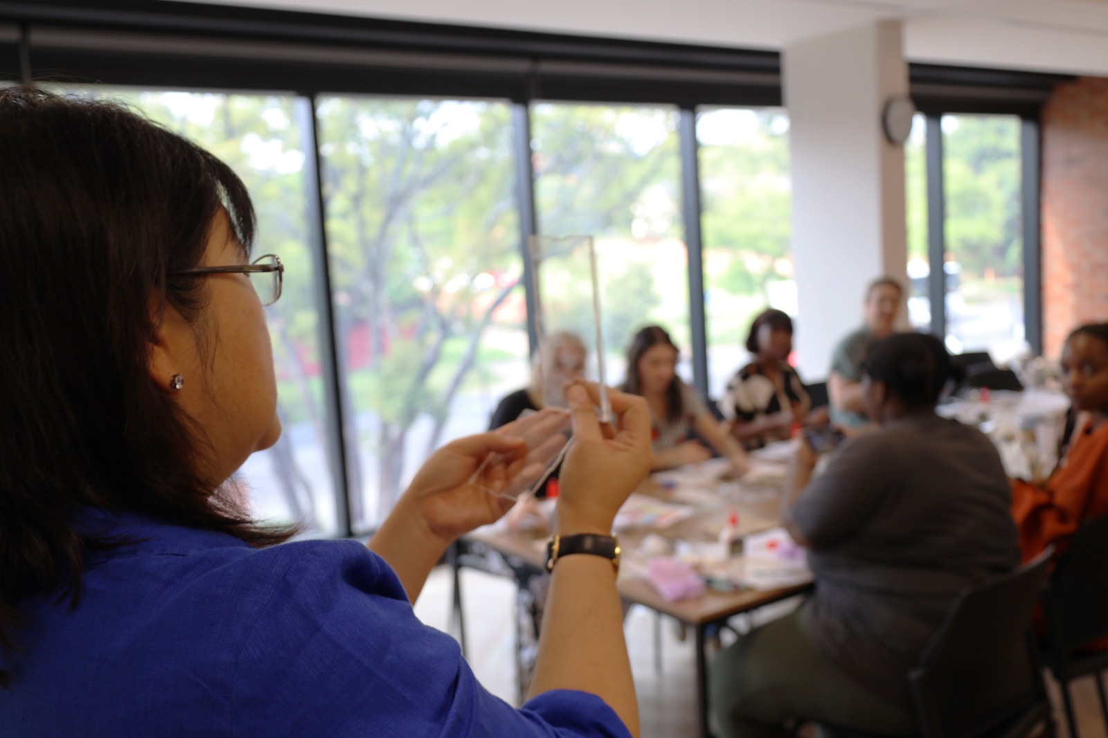 A person holding a cigarette in front of a group of people

Description automatically generated