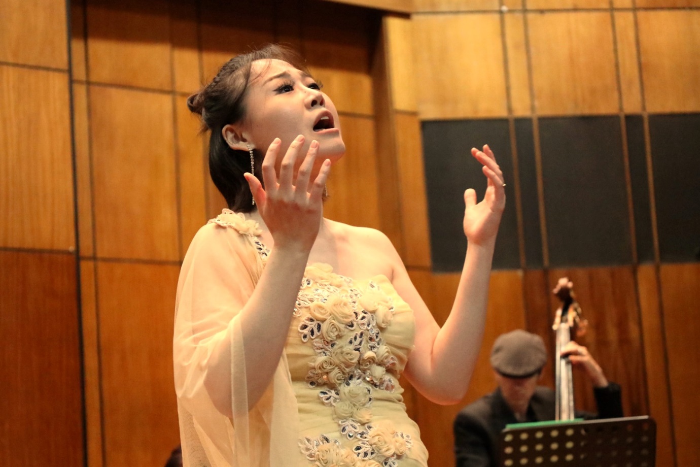 A person in a dress with her hands up

Description automatically generated