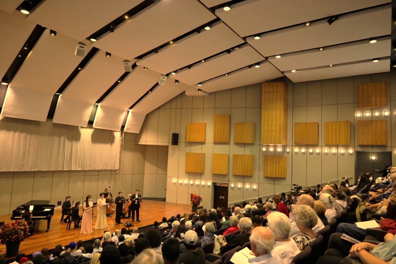 A group of people in a concert hall

Description automatically generated