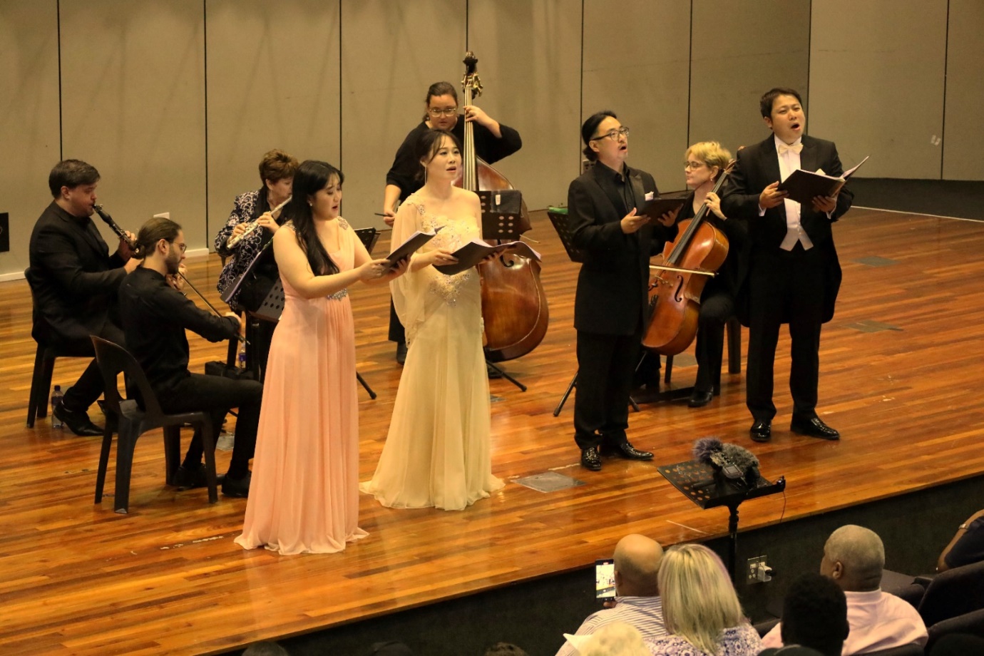 A group of people performing on a stage

Description automatically generated