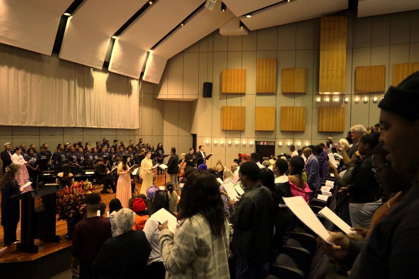 A group of people in a concert hall

Description automatically generated