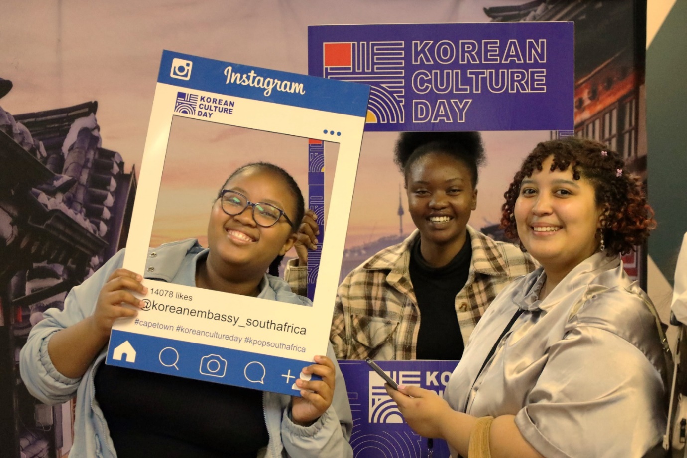 A group of women holding up a photo frame

Description automatically generated