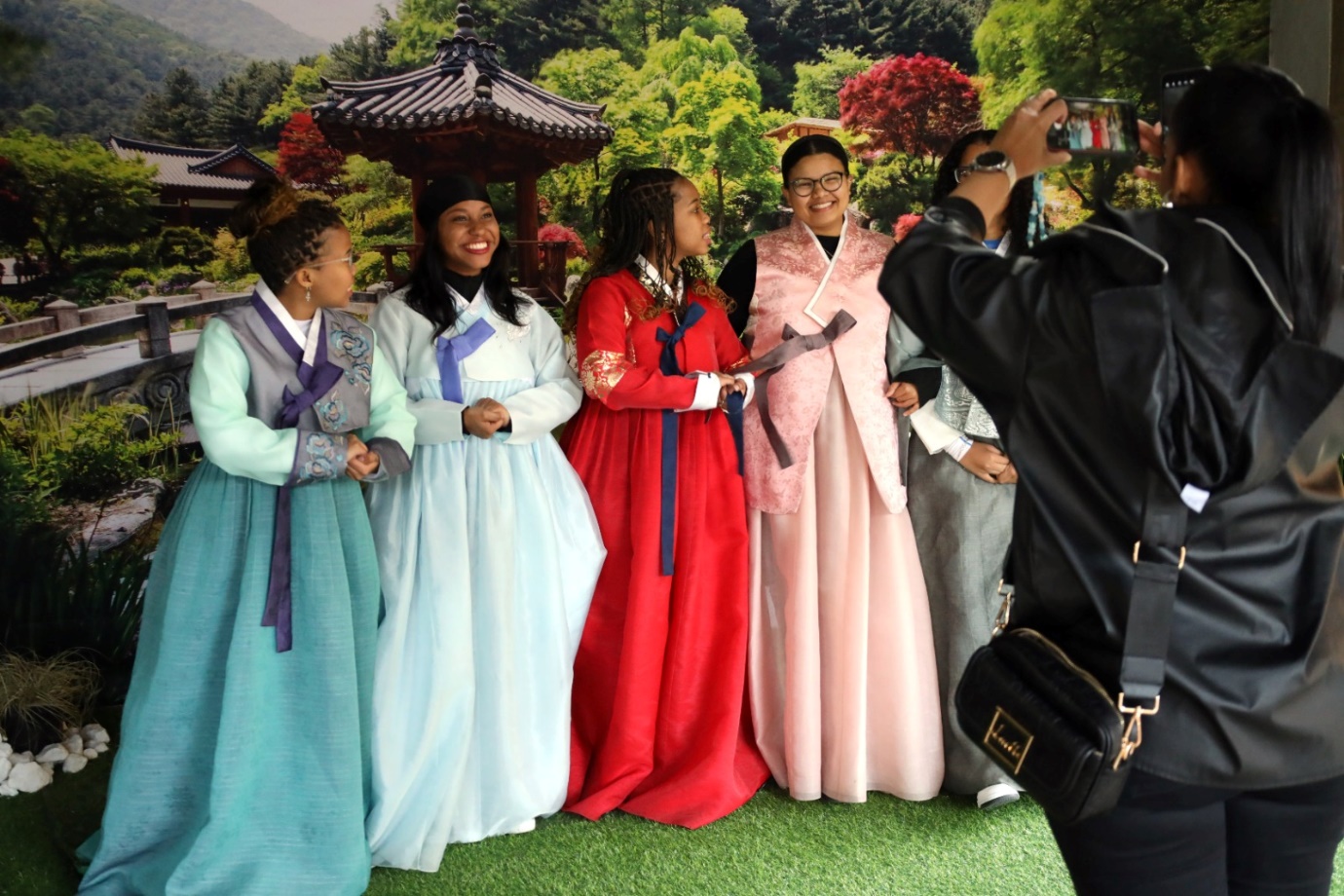 A group of people in dresses posing for a photo

Description automatically generated