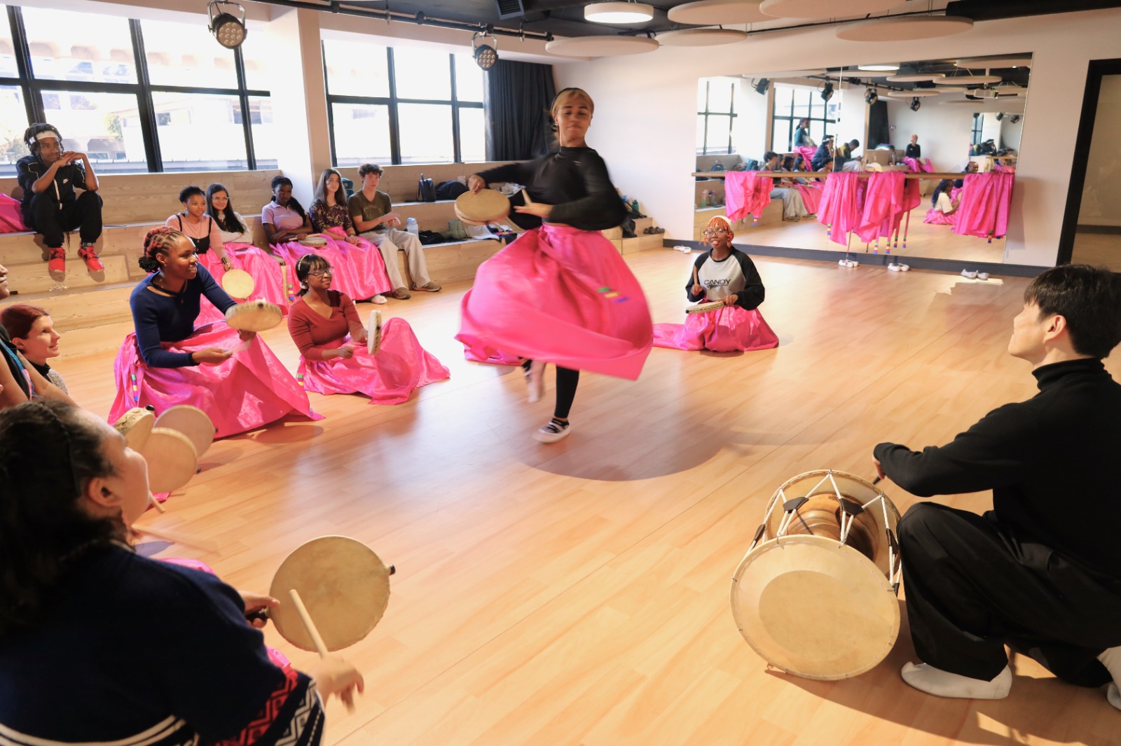 A group of people playing drums

Description automatically generated