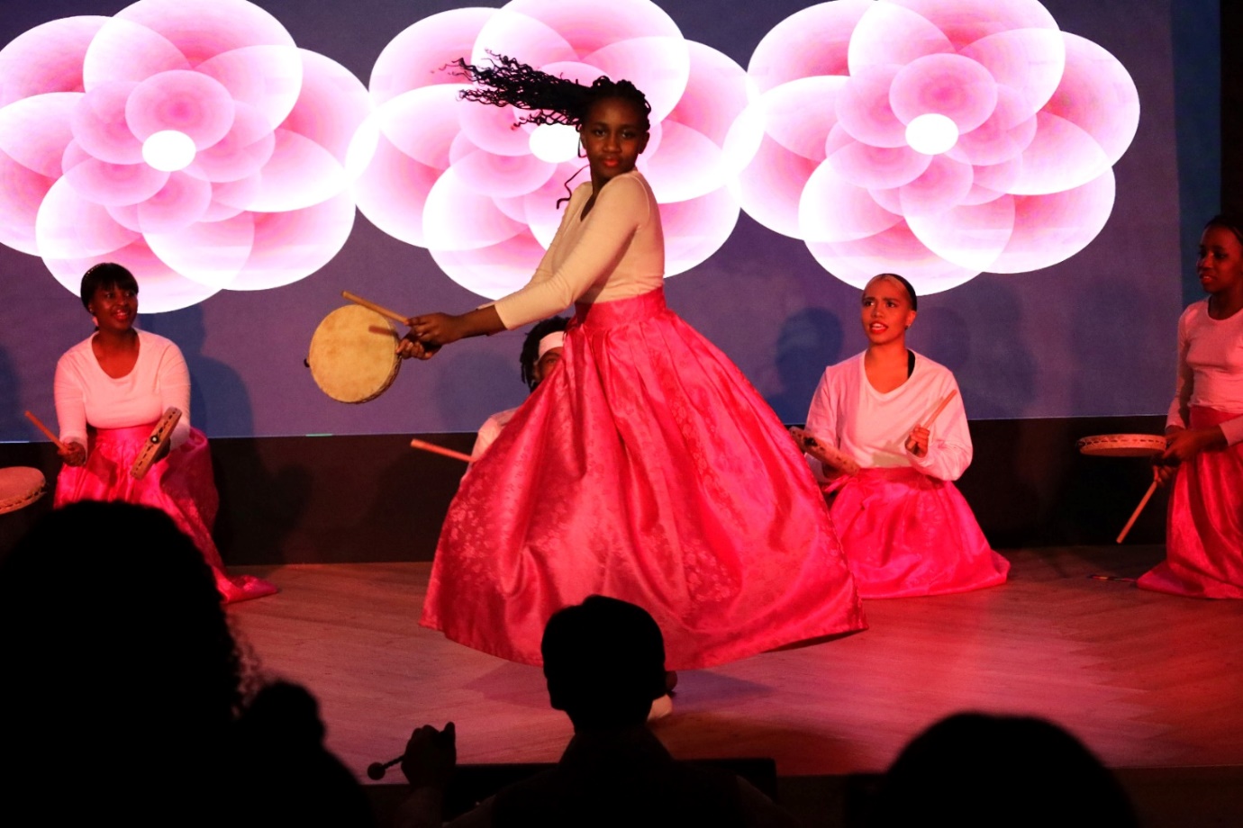 A group of women performing on a stage

Description automatically generated