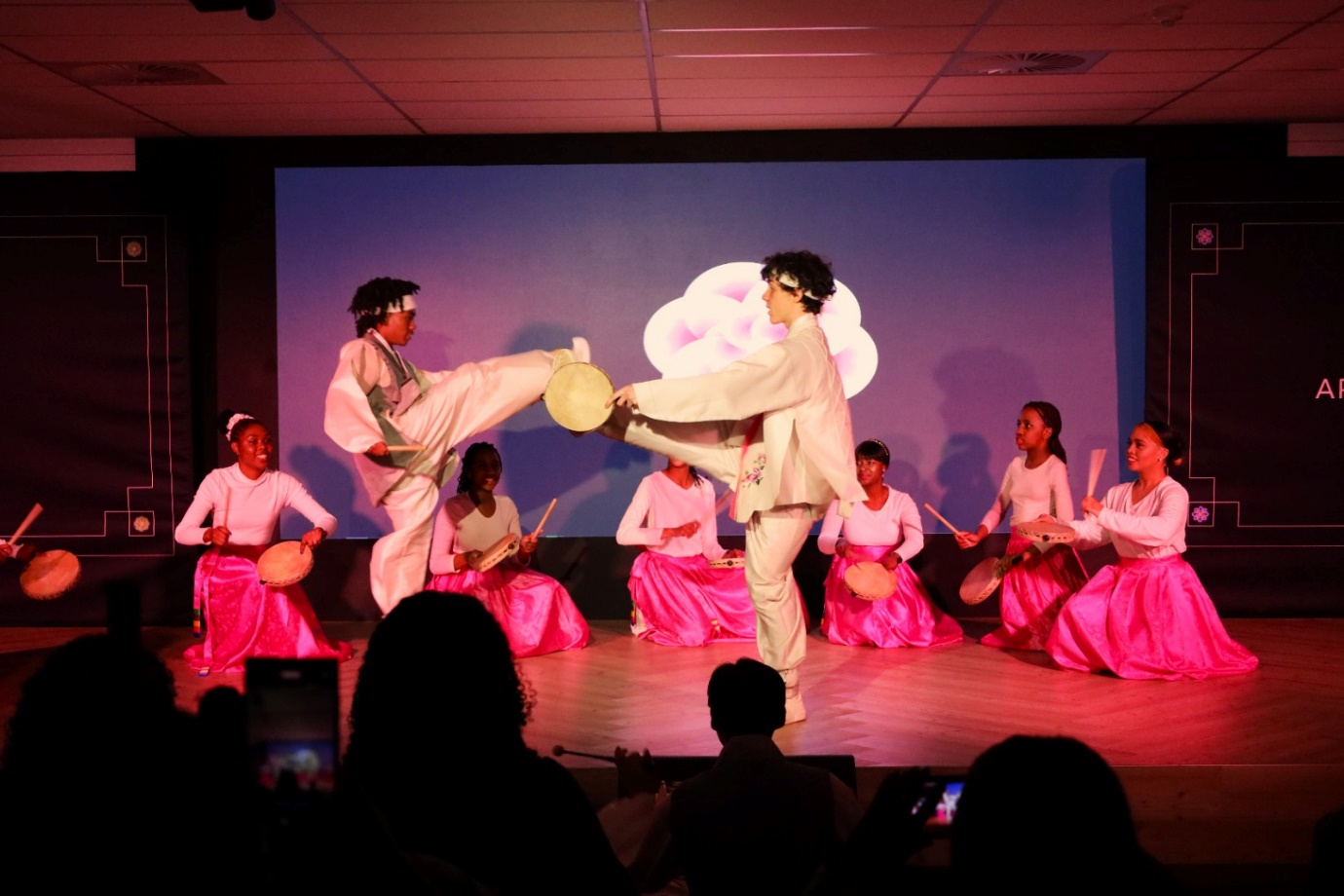 A group of people performing on a stage

Description automatically generated