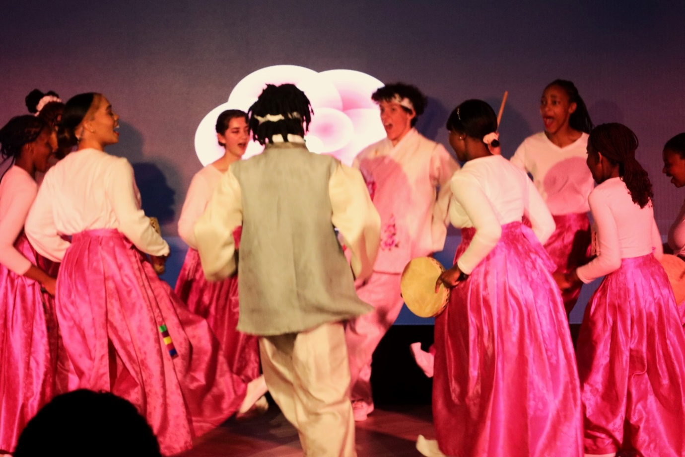 A group of people dancing on a stage

Description automatically generated