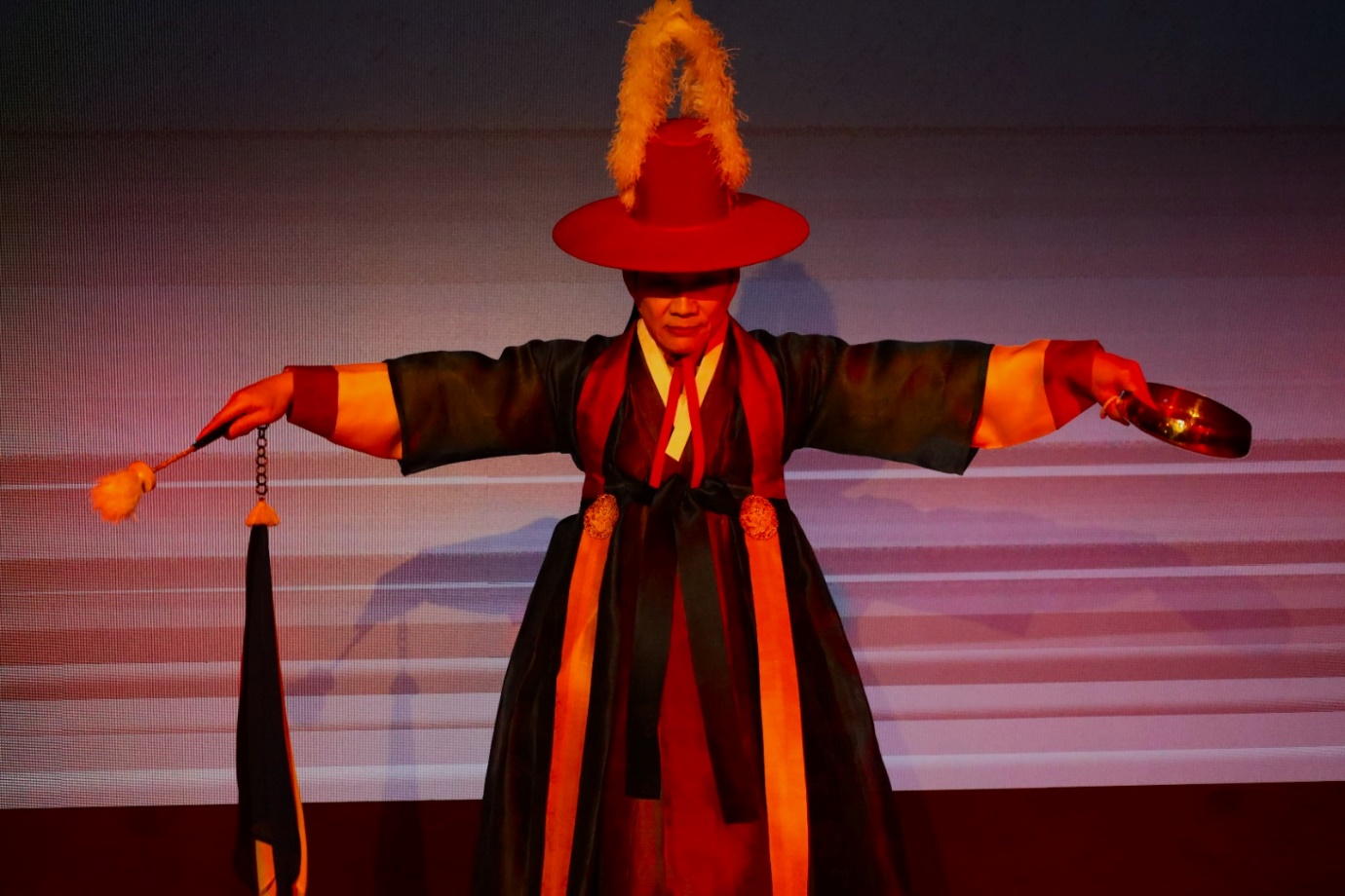 A person wearing a hat and a robe

Description automatically generated