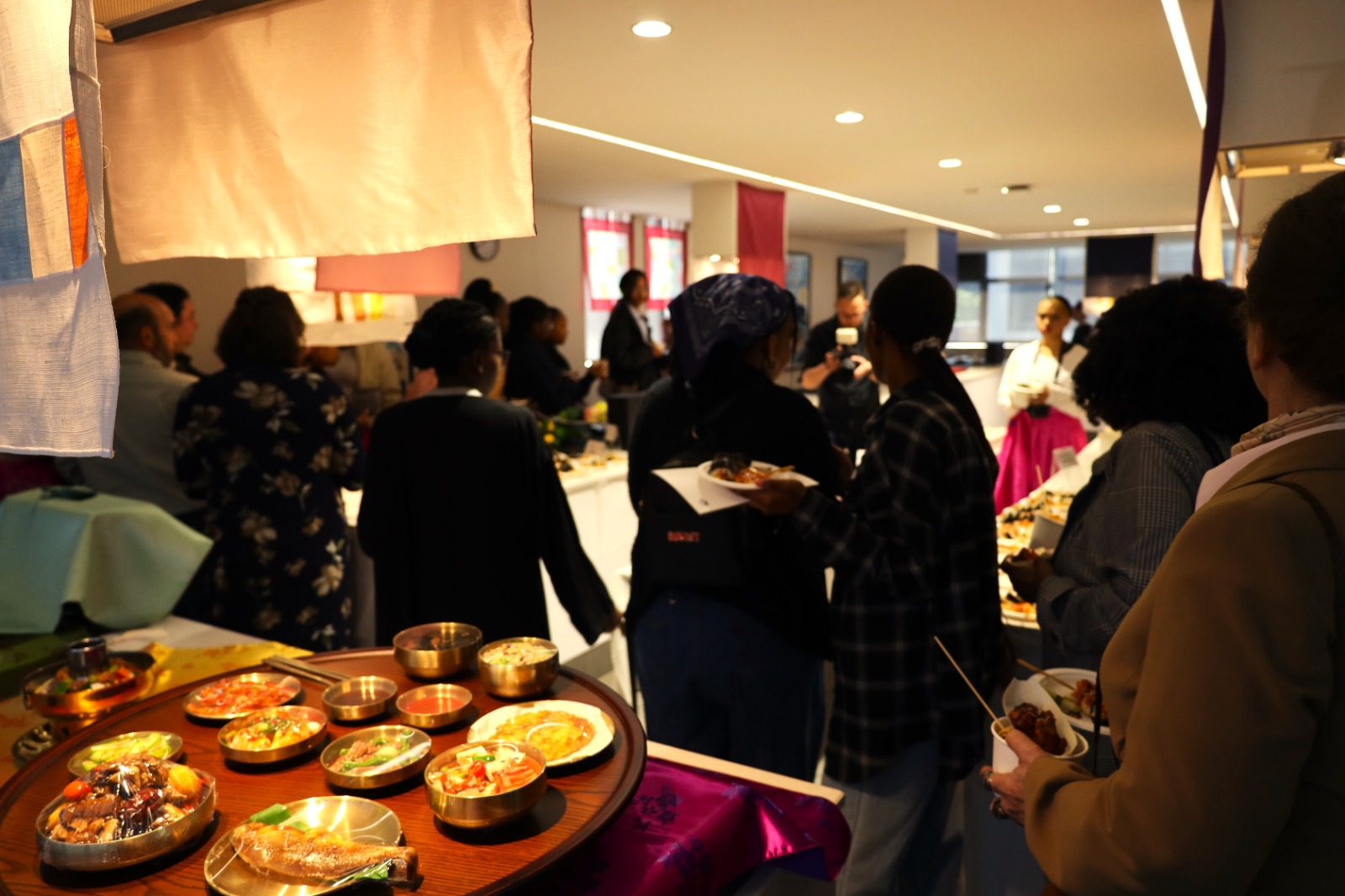 A group of people in a buffet

Description automatically generated