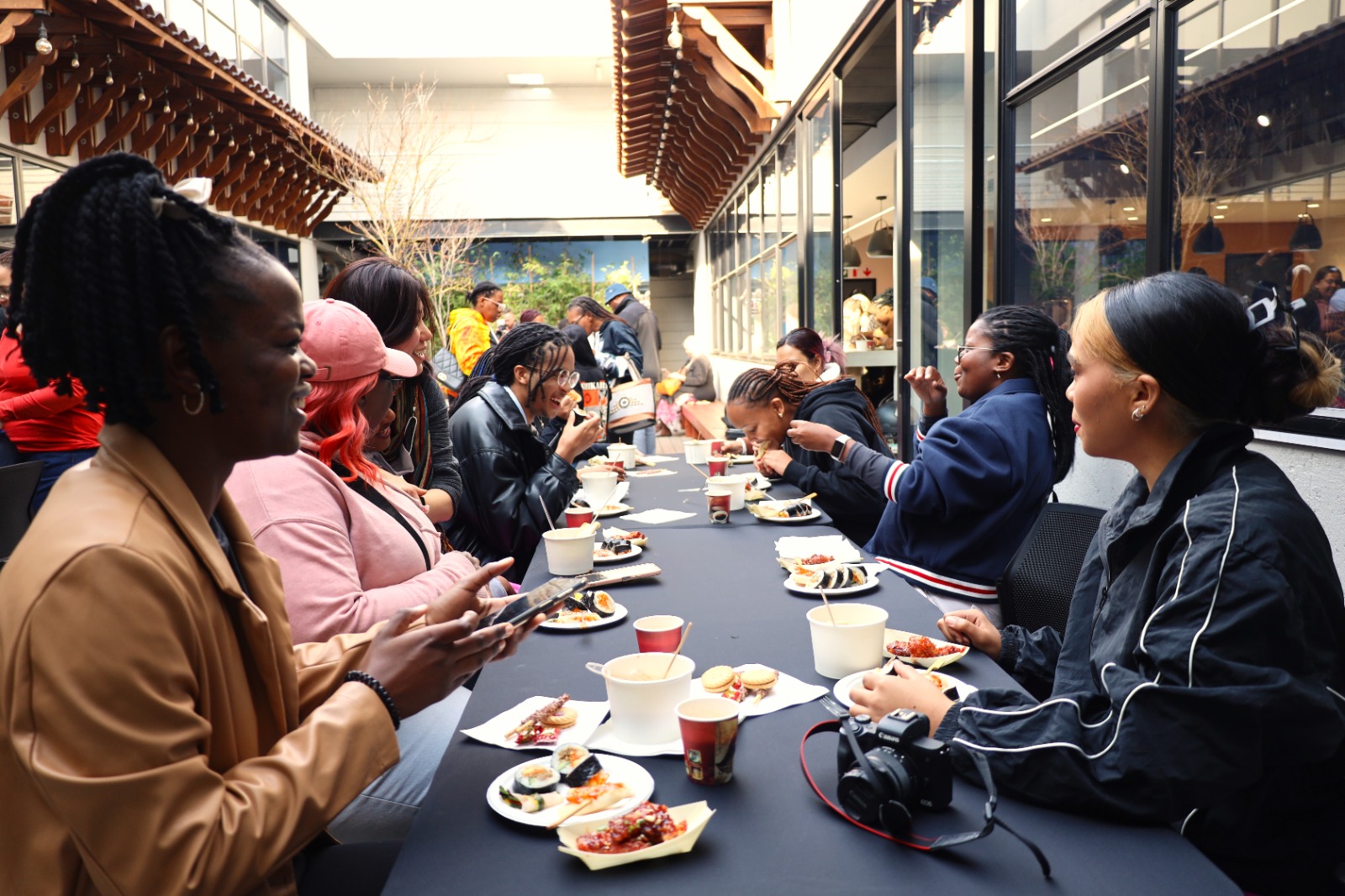 A group of people sitting at a table eating

Description automatically generated