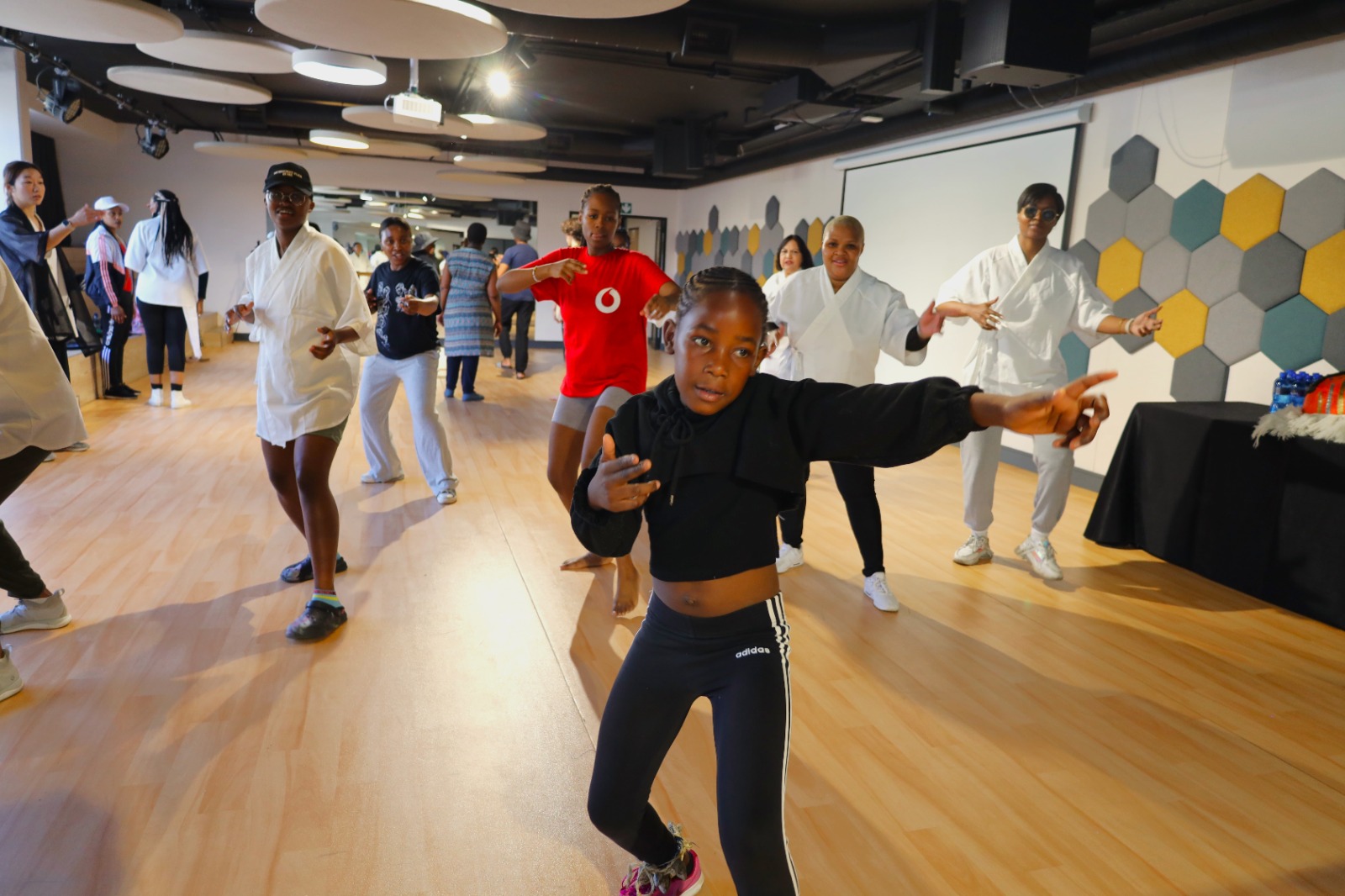 A group of people dancing in a room

Description automatically generated