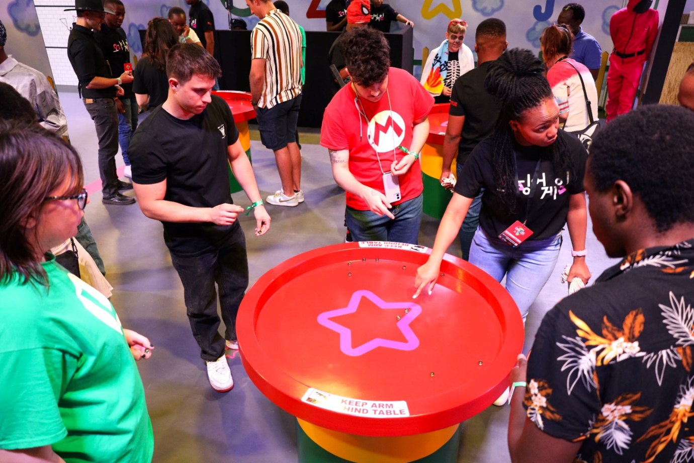 A group of people playing with a star on a table

Description automatically generated