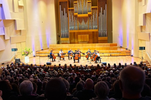 A group of people on stage with a large organ

Description automatically generated
