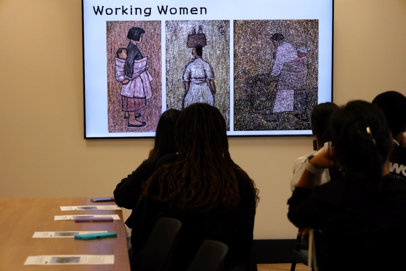 A group of people looking at a projector screen
Description automatically generated