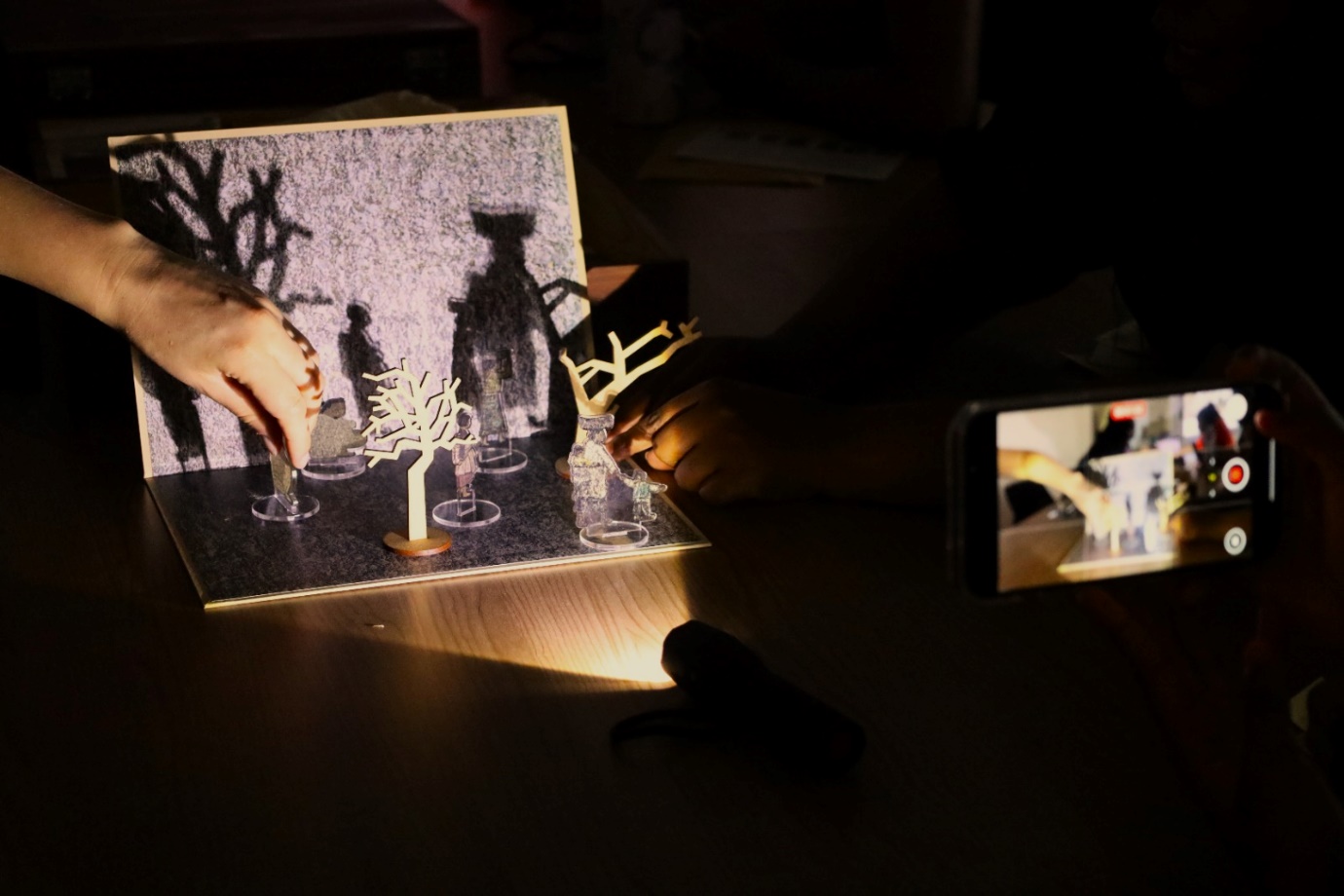 A person using a light up device to create a shadow
Description automatically generated with medium confidence