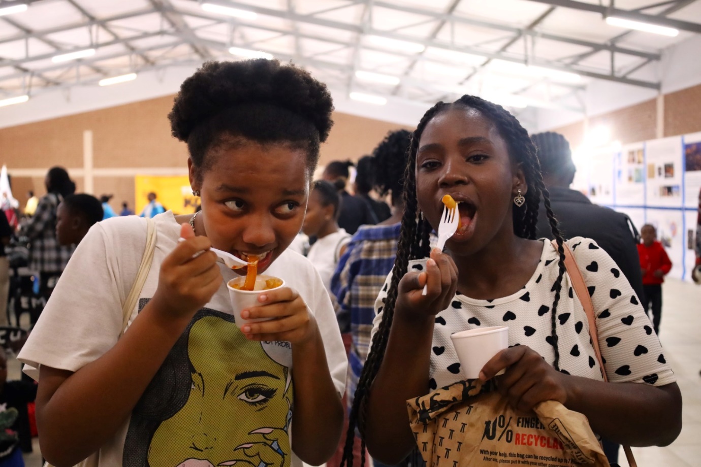 A couple of girls eating food

Description automatically generated