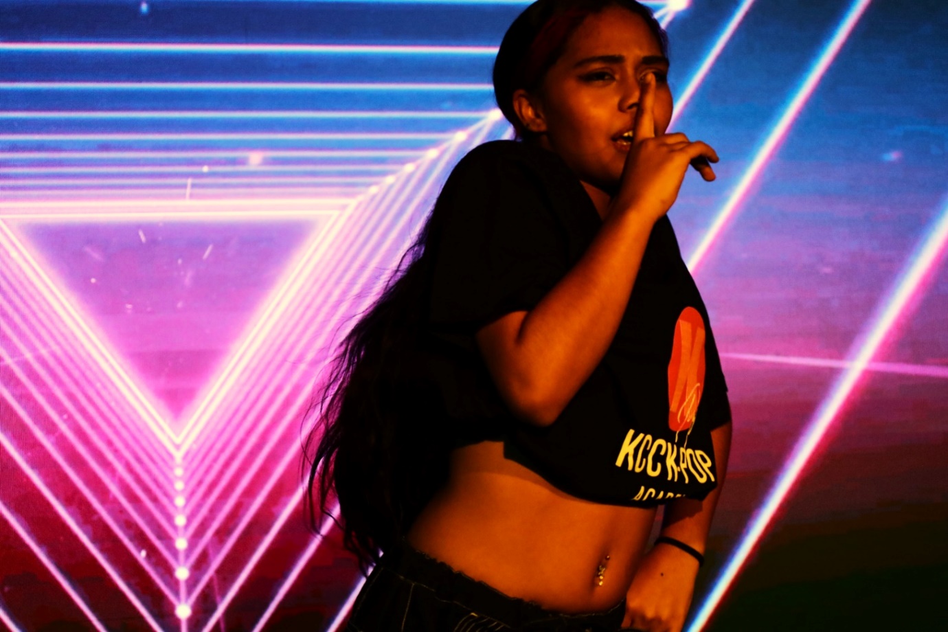 A person with her finger to her mouth
Description automatically generated