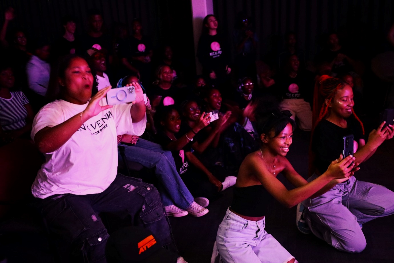 A group of people sitting on the floor
Description automatically generated