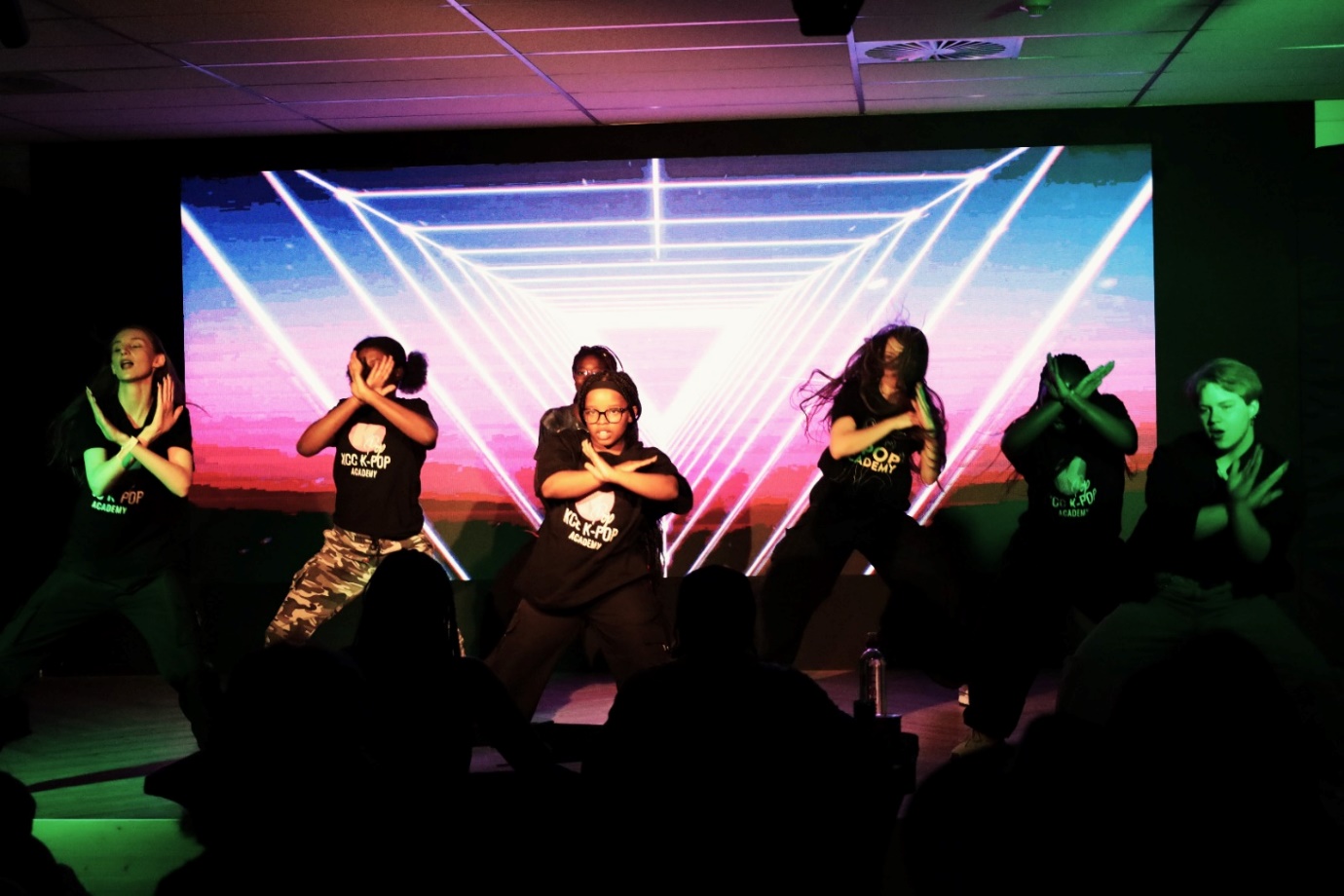 A group of people dancing on a stage
Description automatically generated