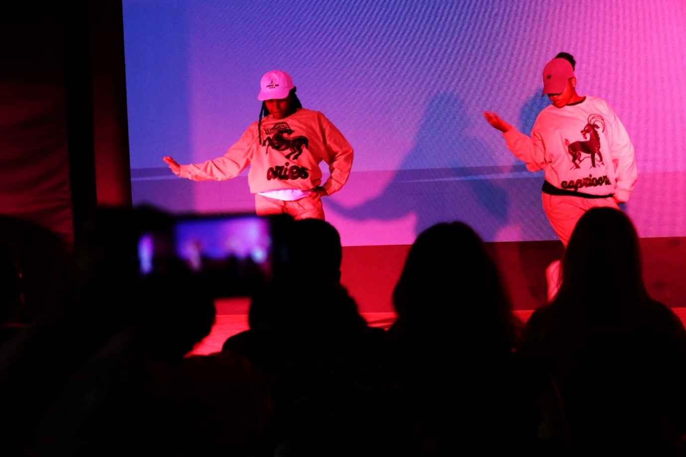 A group of people performing on stage

Description automatically generated