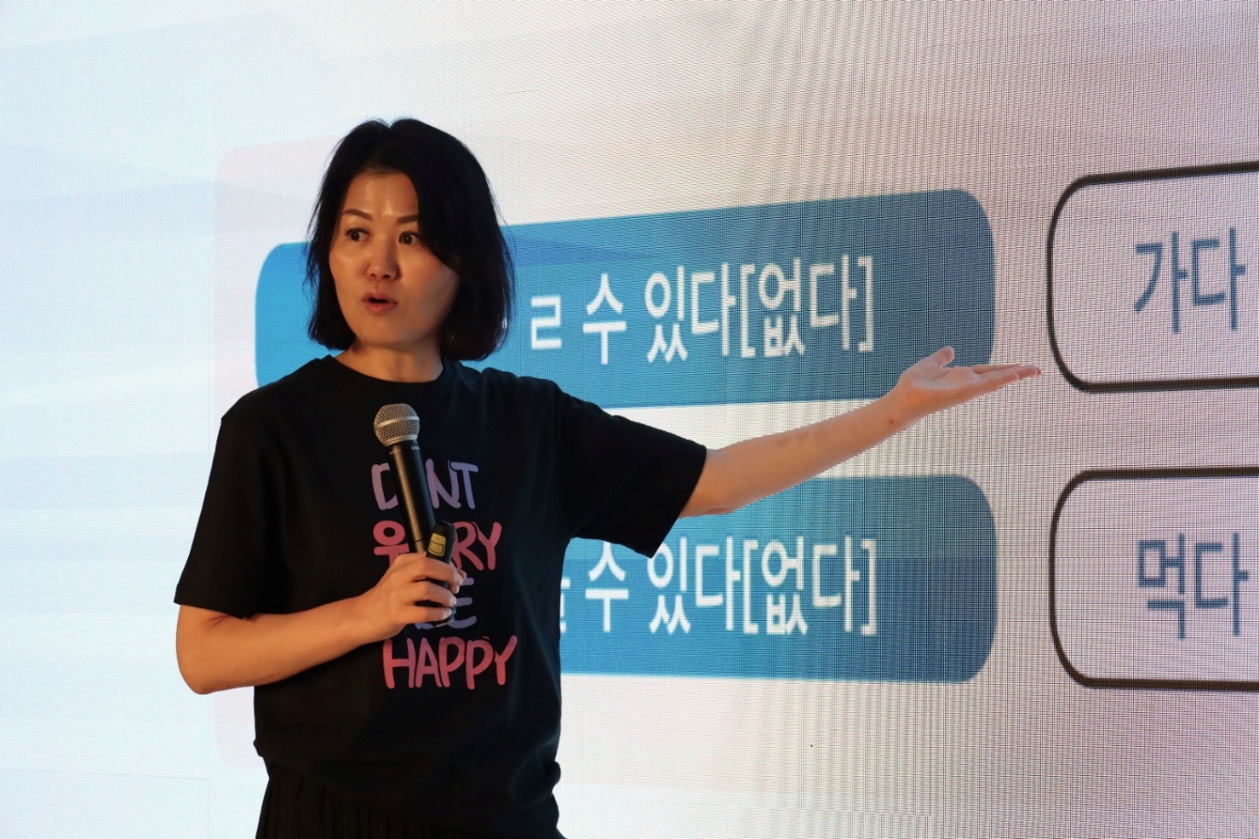 A person standing in front of a screen

Description automatically generated