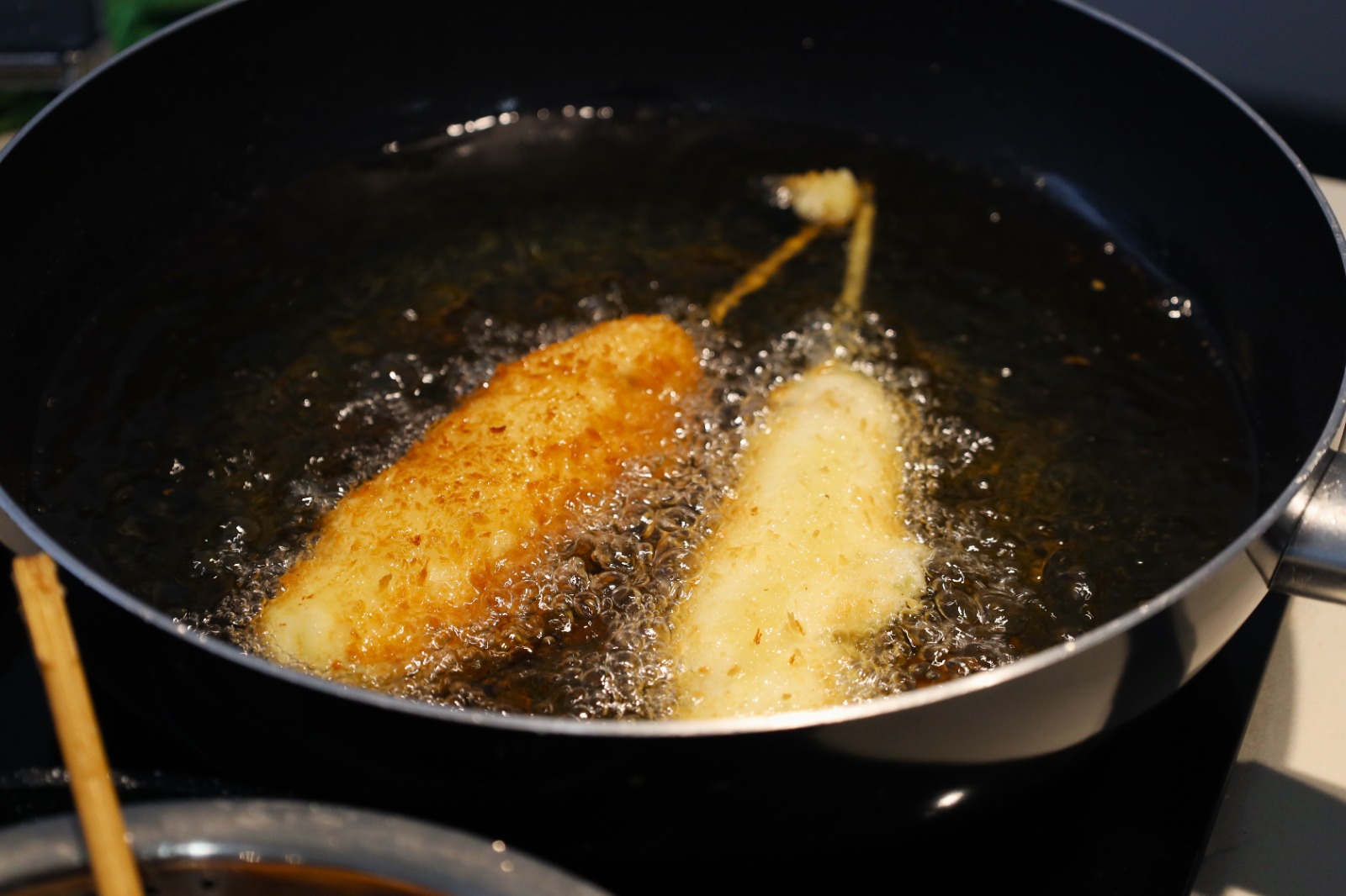 Food in a pan frying in oil

Description automatically generated