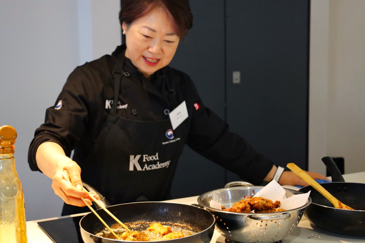 A person cooking food in a kitchen

Description automatically generated