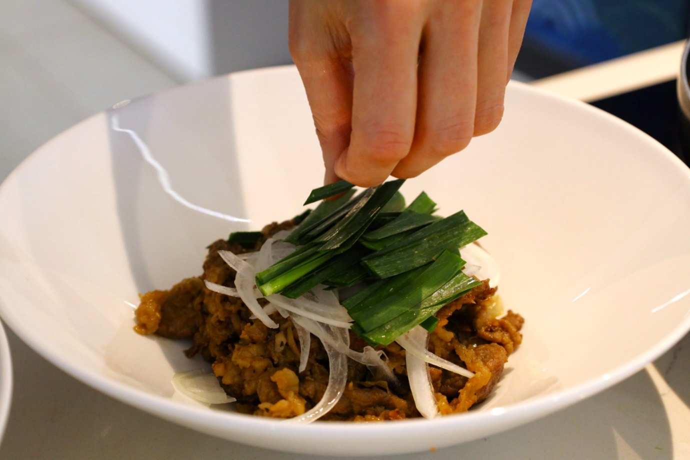 A person putting some food on a plate

Description automatically generated with medium confidence