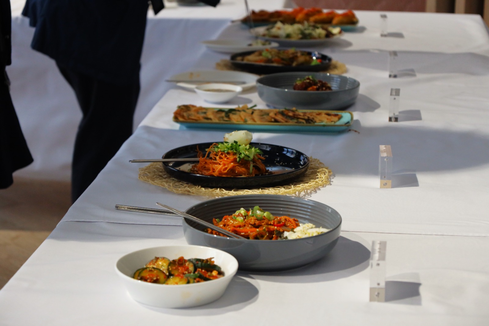 A long table with plates of food

Description automatically generated