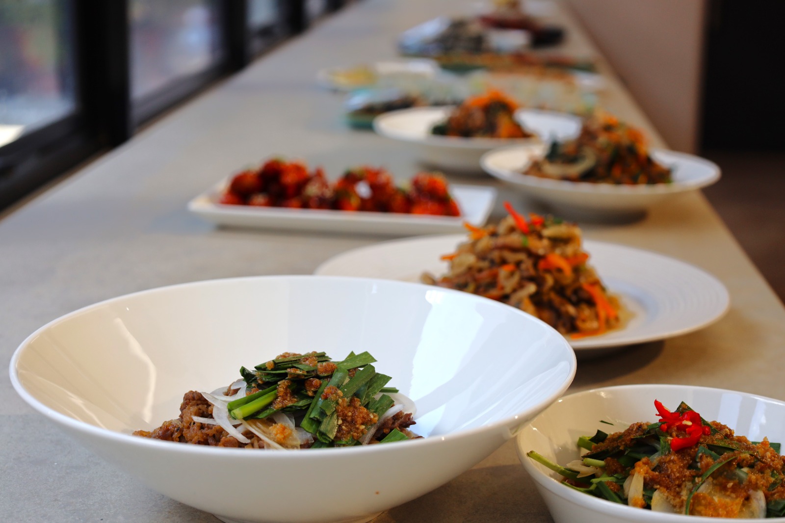 A row of bowls of food

Description automatically generated