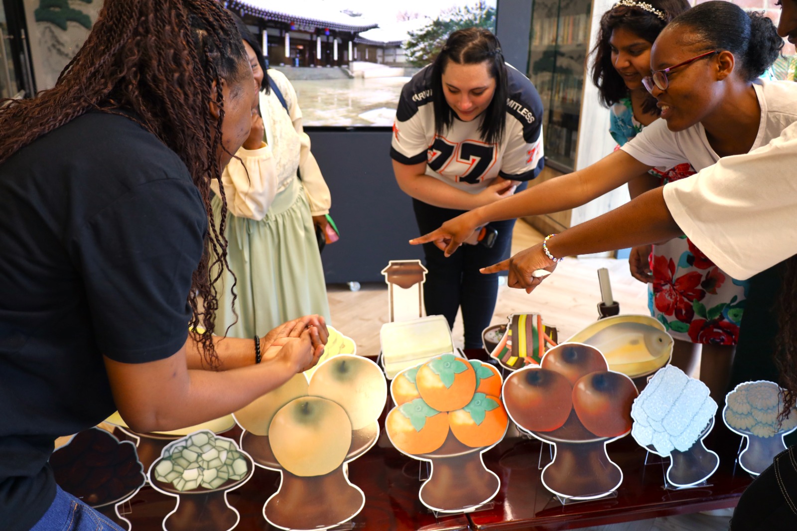 A group of people standing around a table

AI-generated content may be incorrect.