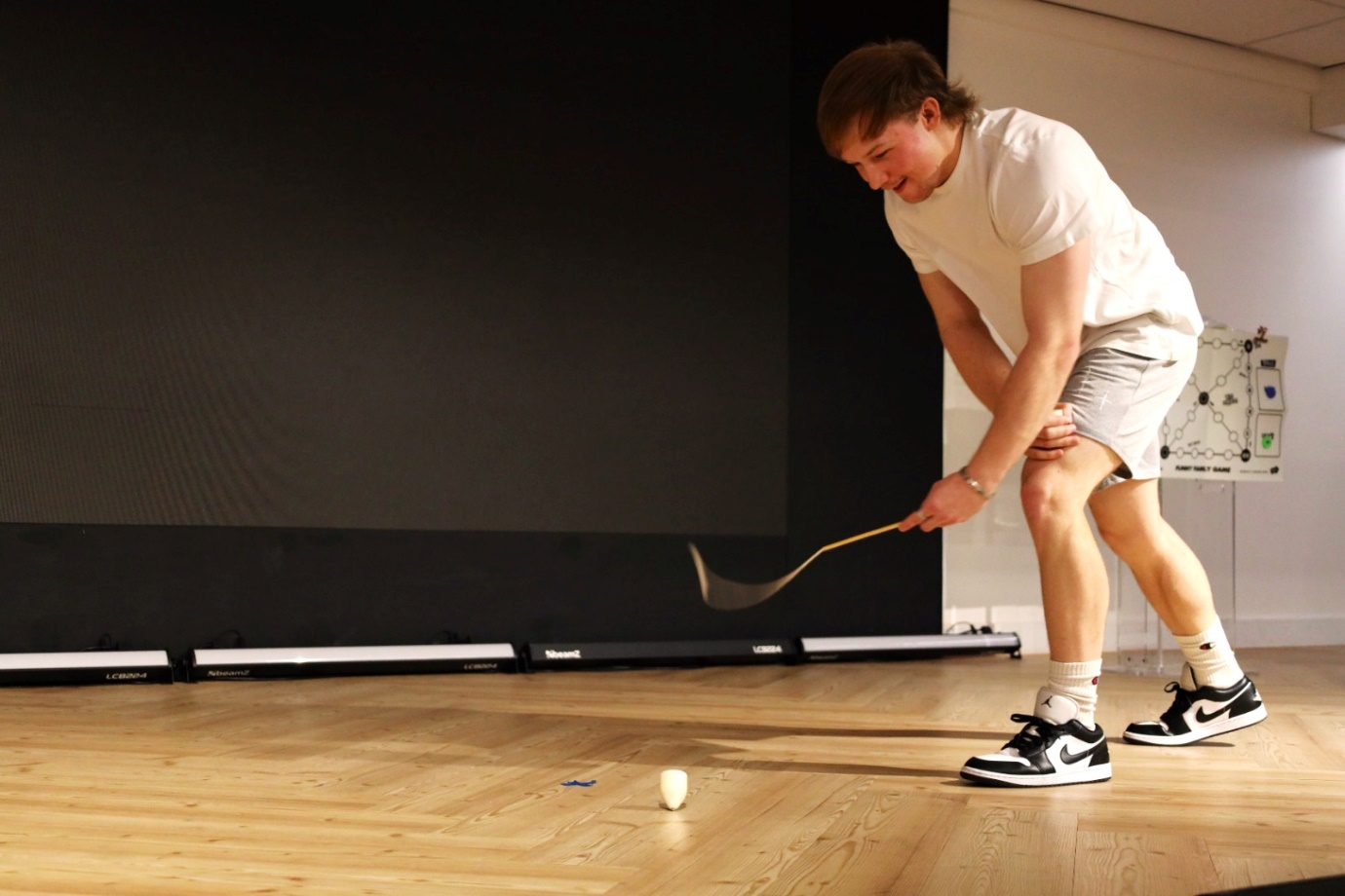 A person playing golf on a wooden floor

AI-generated content may be incorrect.