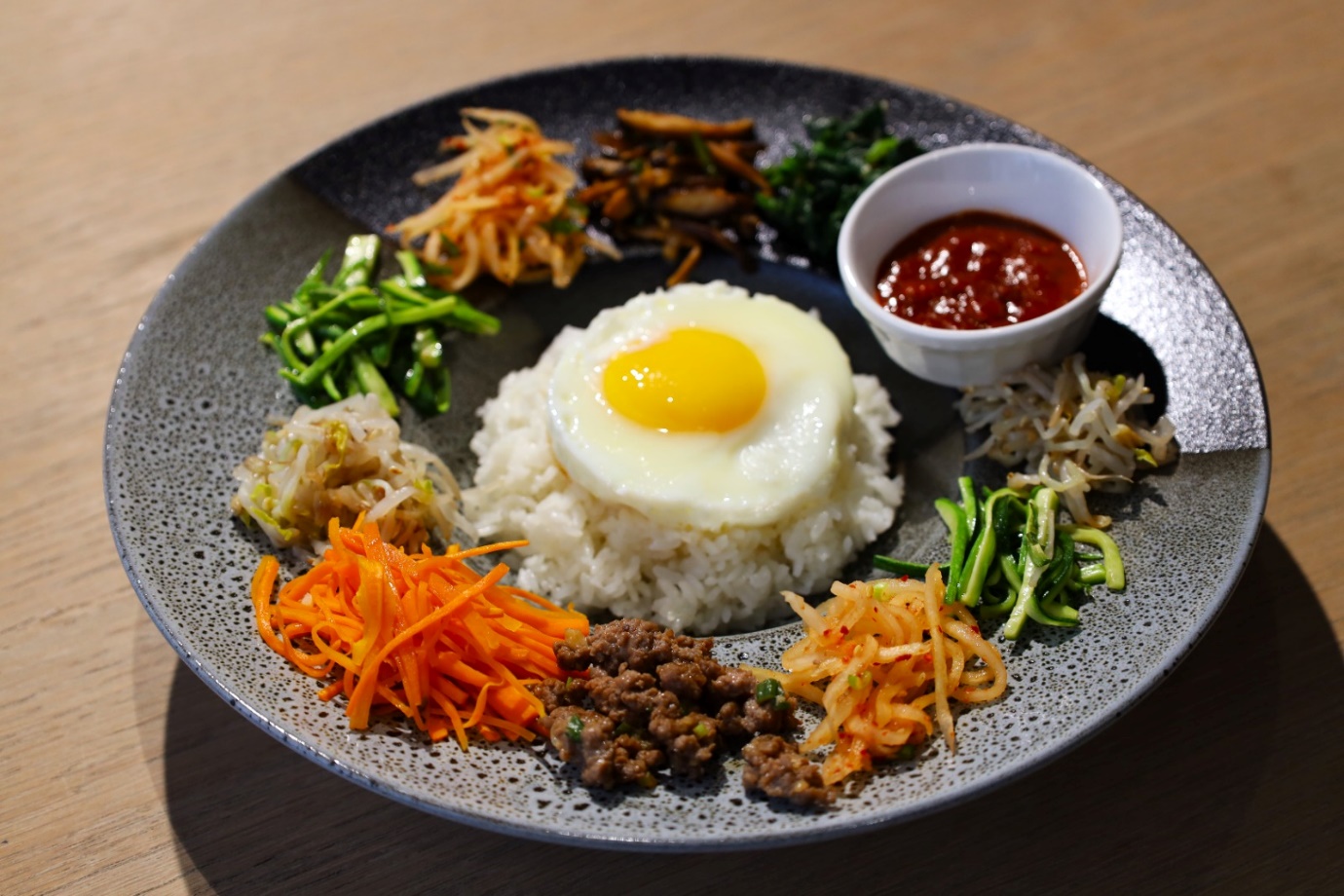 A plate of food with a fried egg and vegetables

AI-generated content may be incorrect.