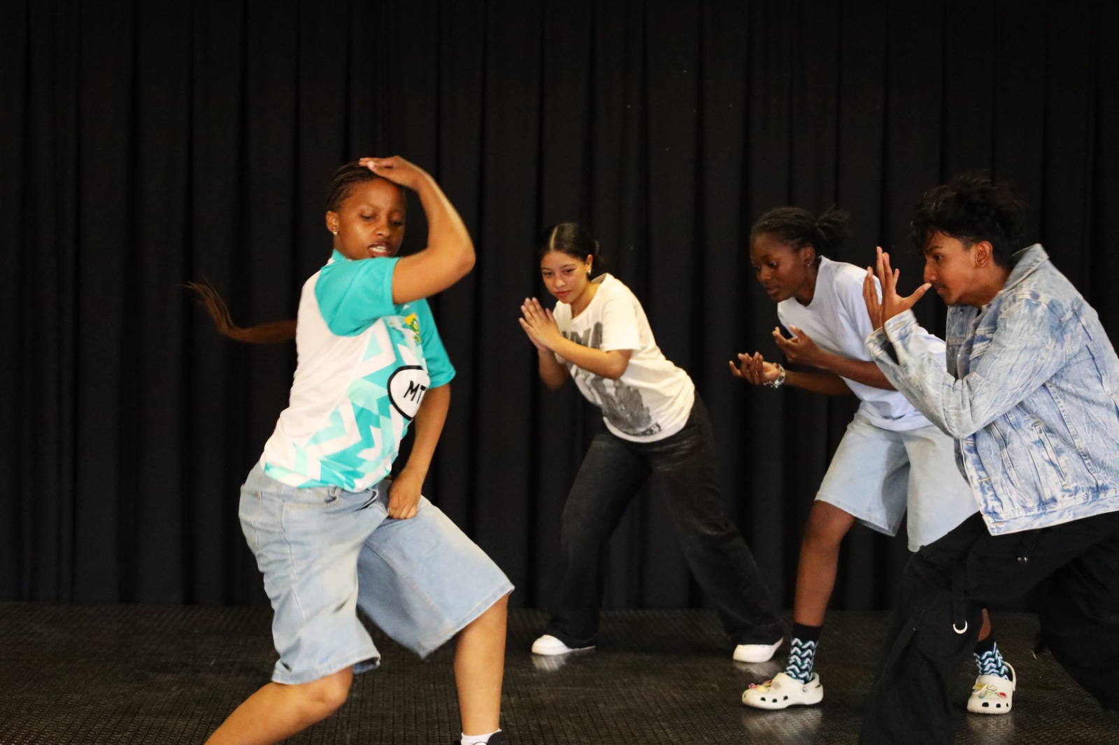 A group of people dancing on a stage

AI-generated content may be incorrect.
