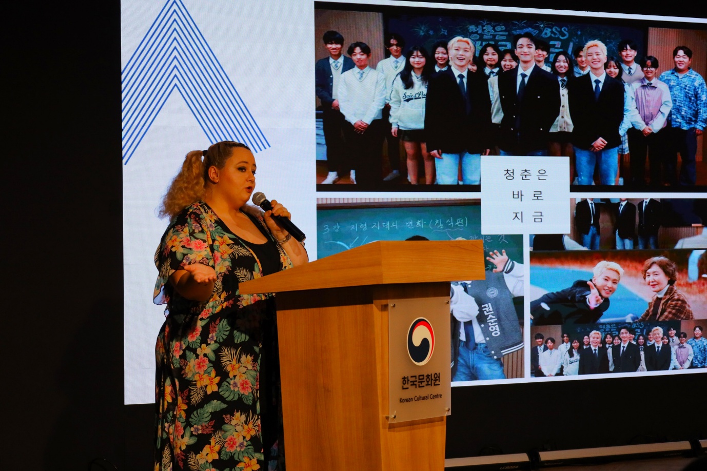 A person standing at a podium with a microphone

AI-generated content may be incorrect.