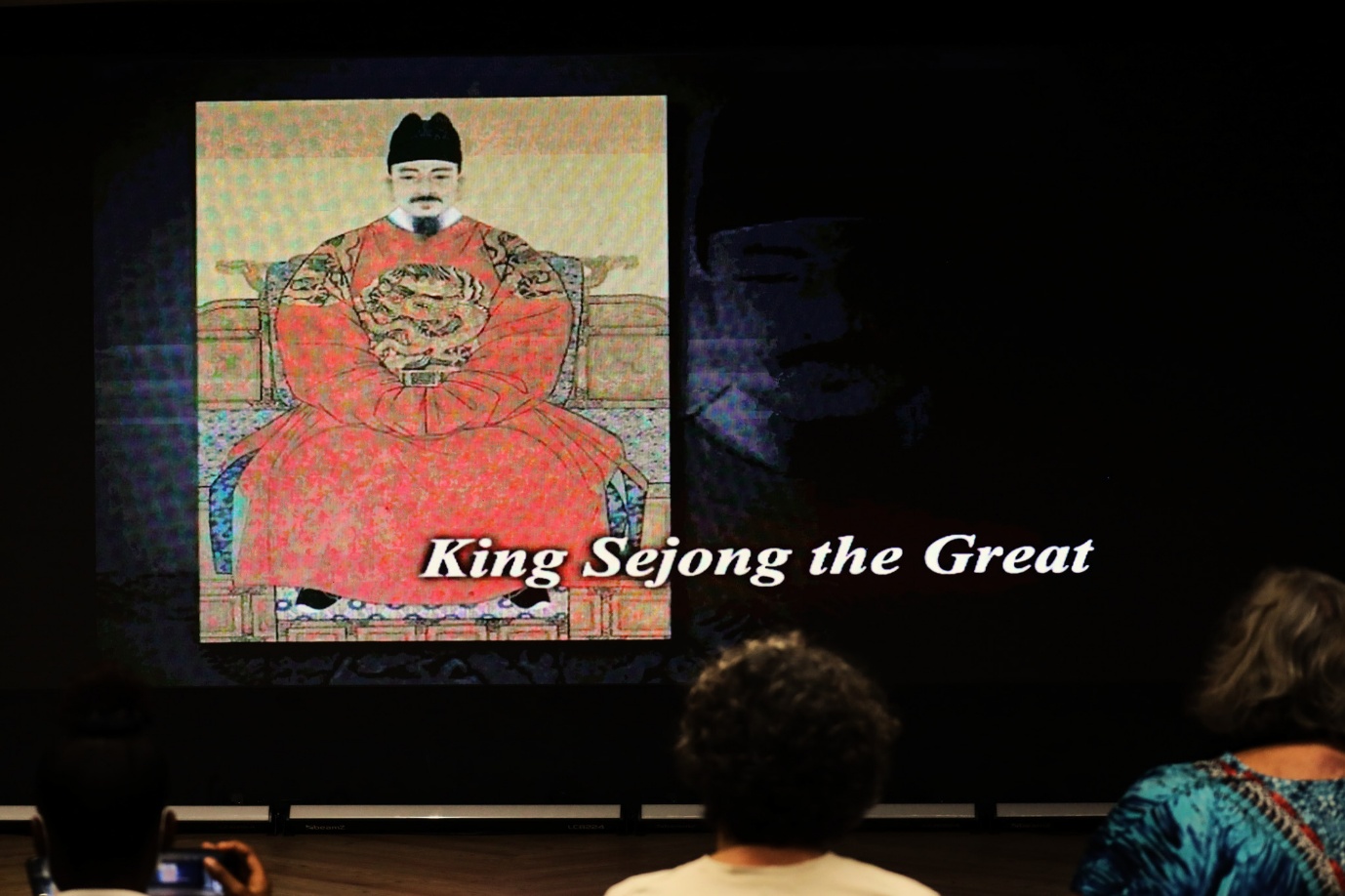 A person in a red robe sitting in front of a person in a red robe

AI-generated content may be incorrect.