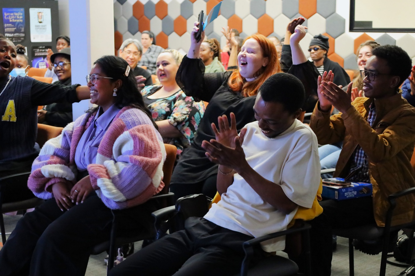 A group of people sitting in chairs clapping

AI-generated content may be incorrect.